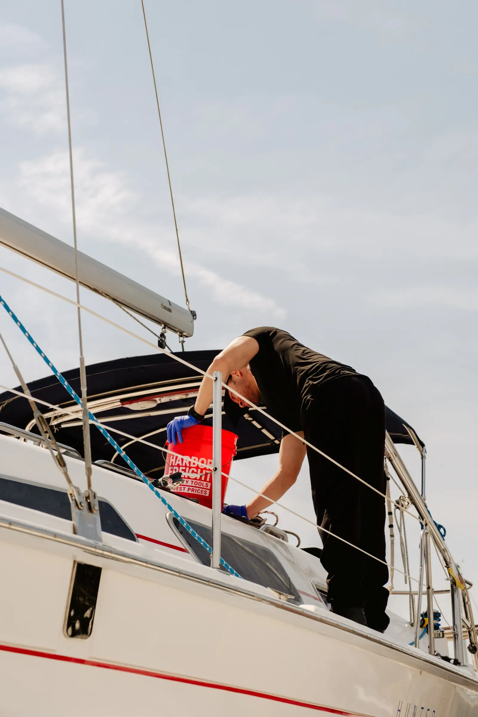 Dynamite Details technician washing a sailboat at the dock