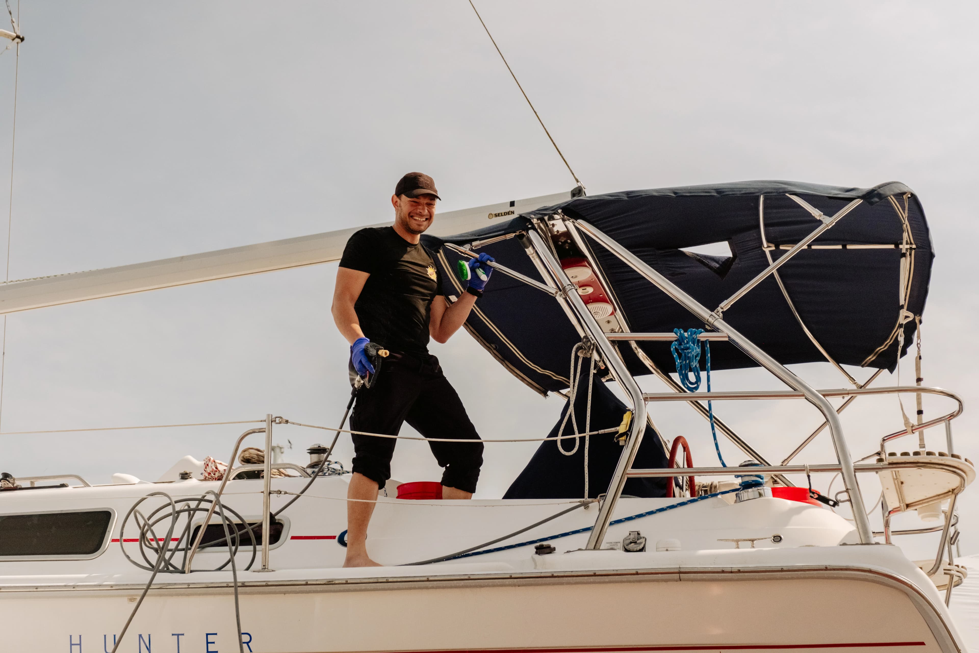 Dynamite Details detailer working on a sailboat deck at sunset