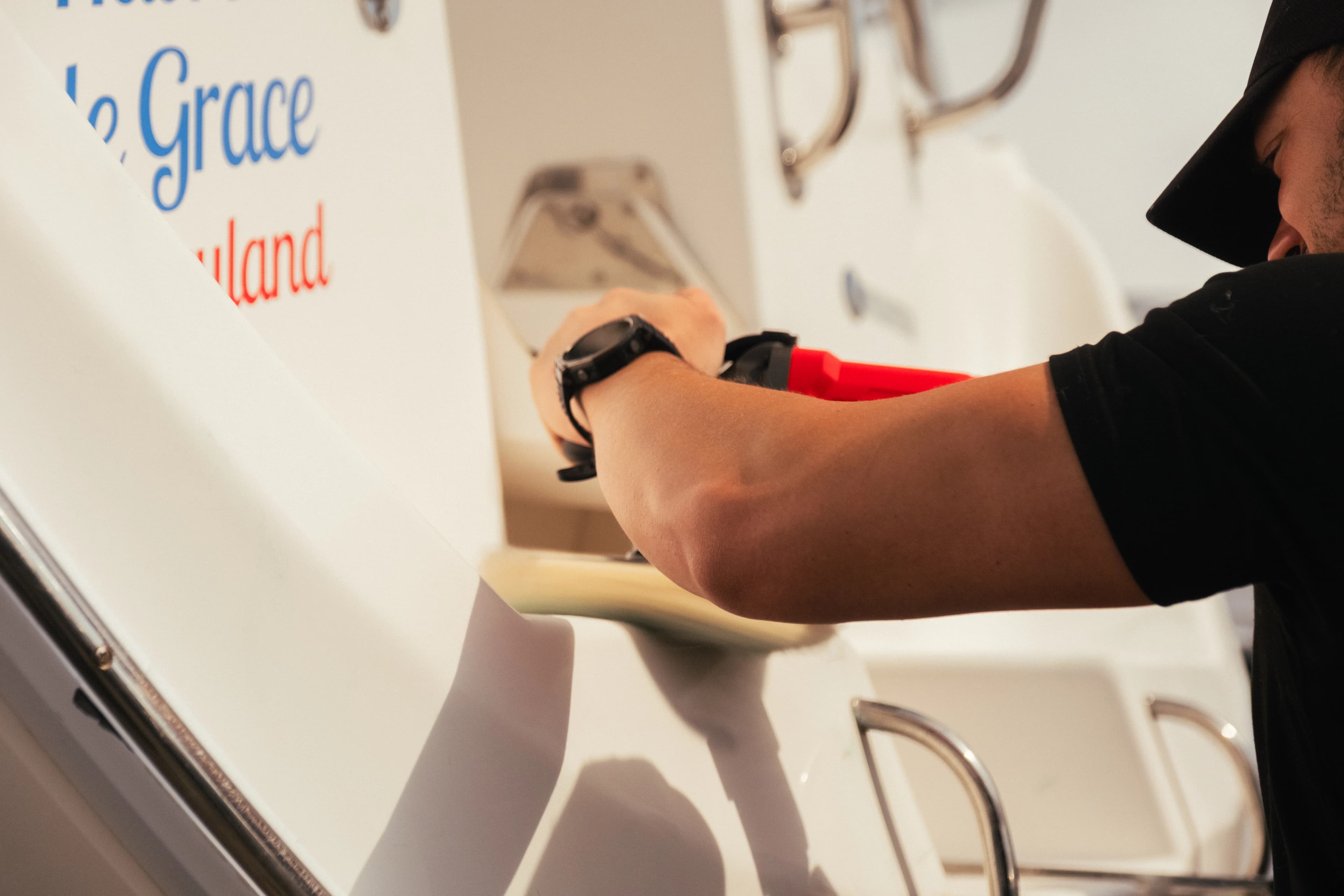 Detailer polishing the gel coat on a boat hull