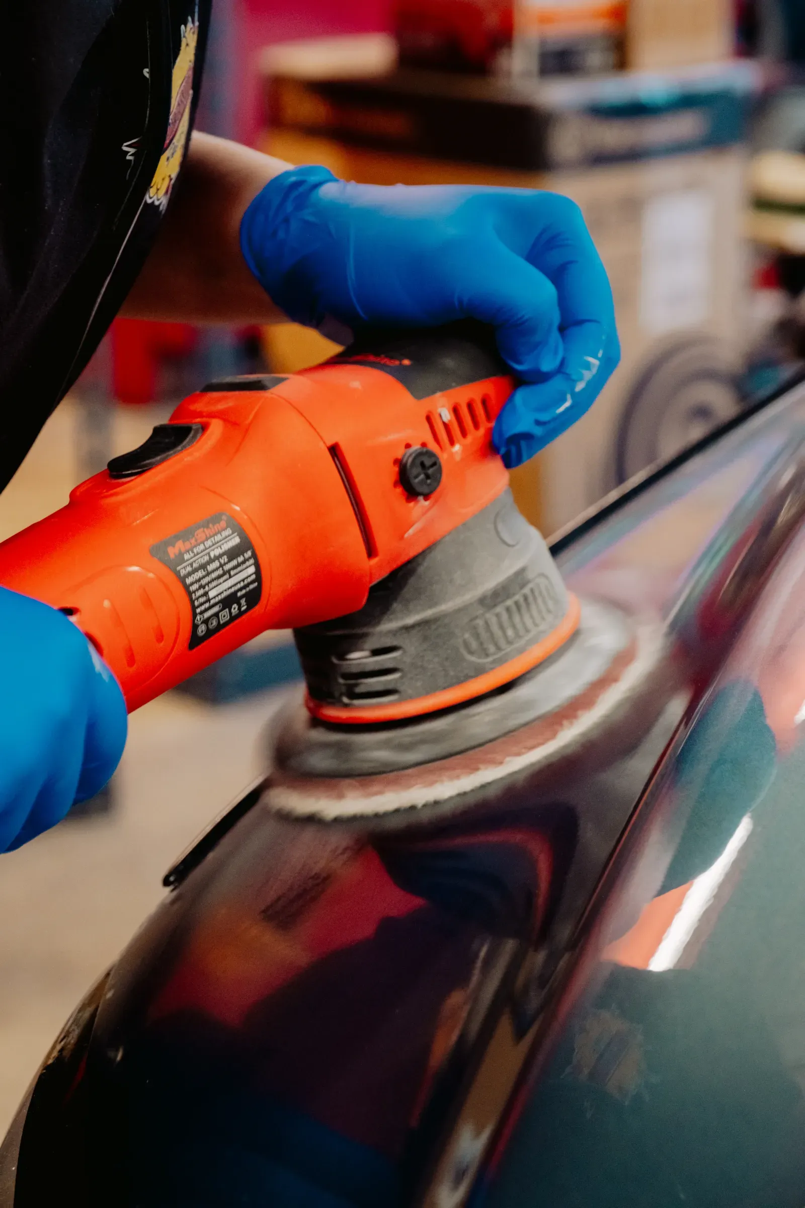 Dual-action polisher correcting paint on a vehicle panel