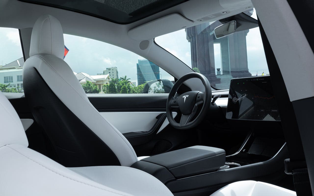 Tesla interior with white seats and panoramic glass roof