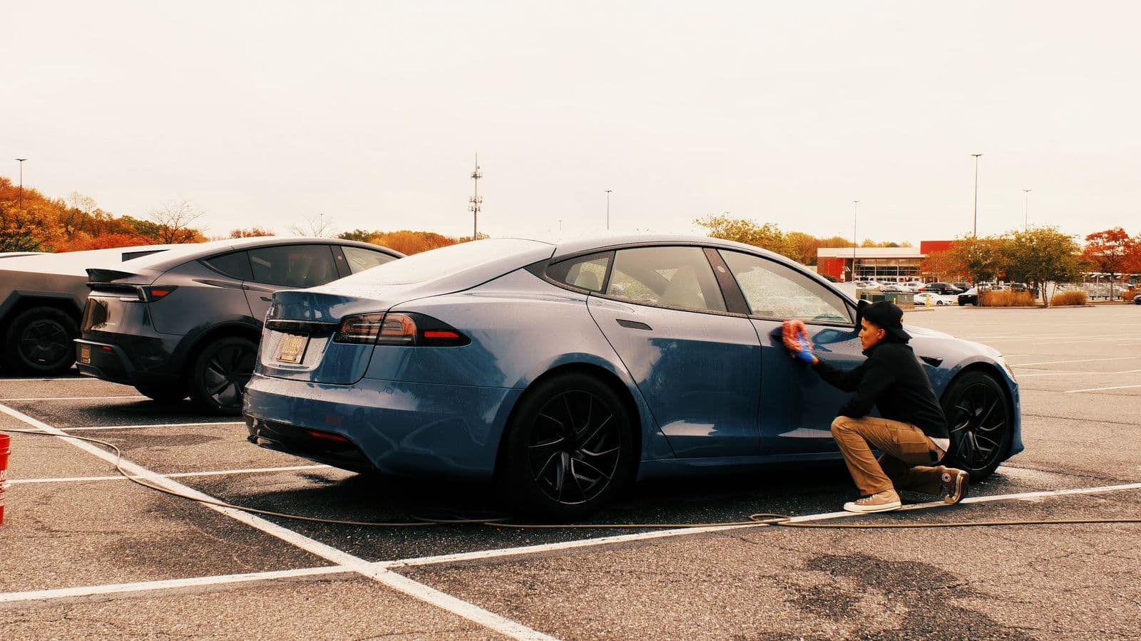 Blue Tesla being hand-washed by a Dynamite Details technician