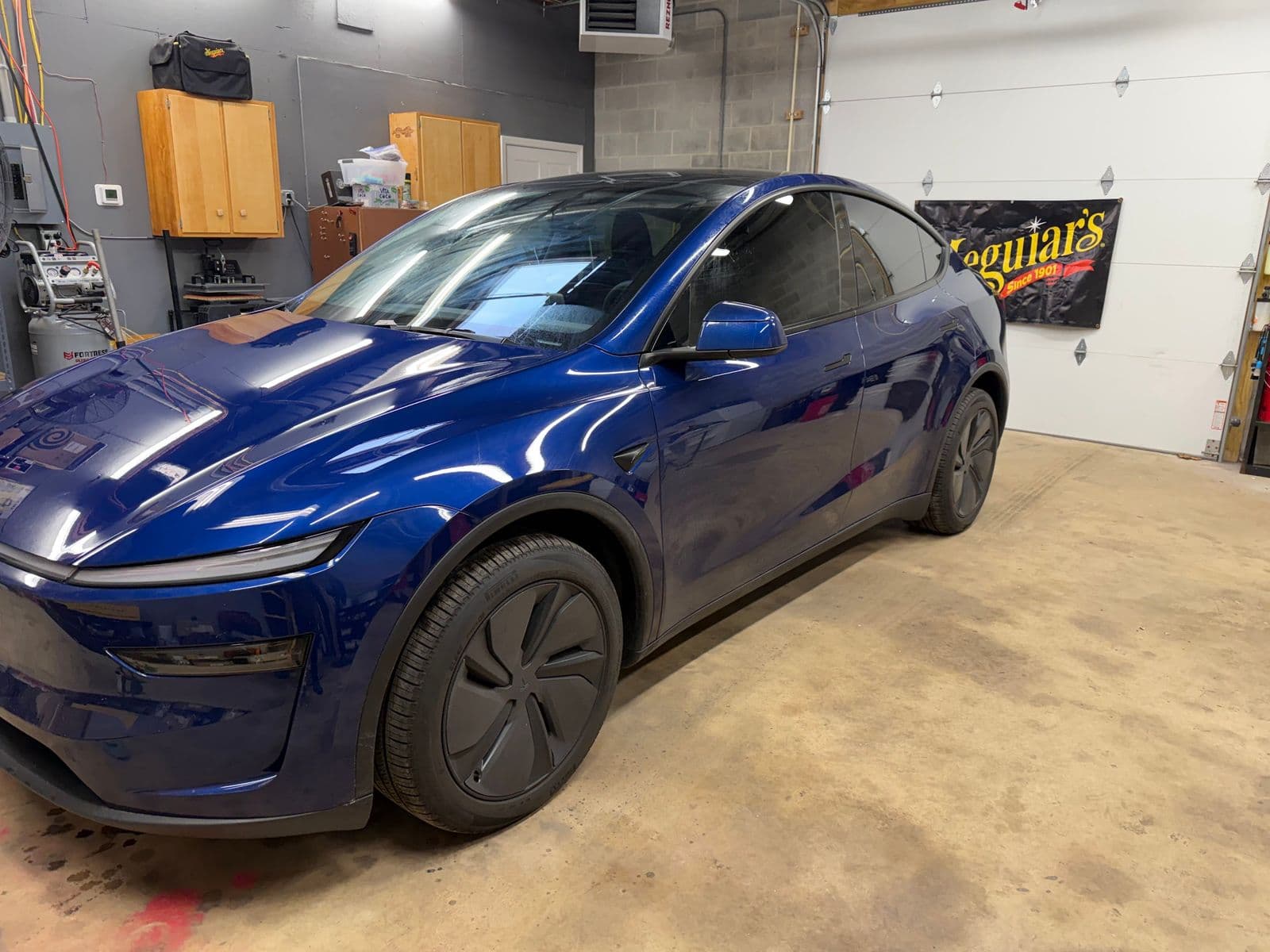 Blue Tesla Model Y with glossy paint inside the Dynamite Details studio in Middletown, DE